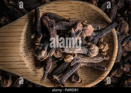 Cuillère en bois avec des clous de girofle dans un tas de girofle Banque D'Images