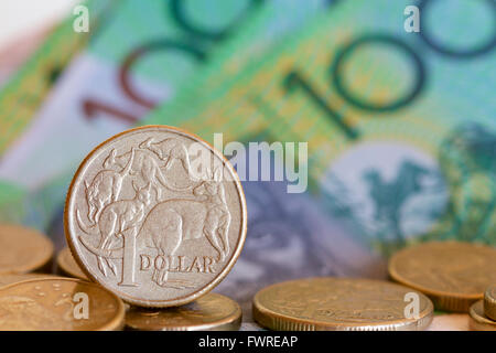 Pièce d'un dollar australien sur un fond de pièces et d'une centaine de dollars. Banque D'Images