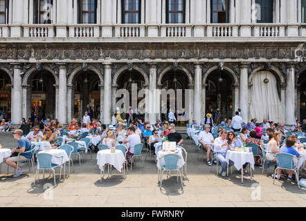 Les touristes assis à l'extérieur du Caffe Aurora en St Mark's Square, San Marco, Venise, Italie Banque D'Images