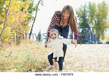 Aider la mère à fille bébé walk in park