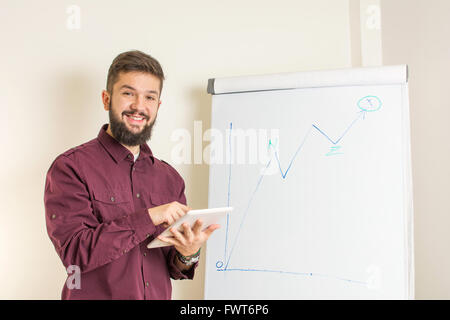 Jeune homme barbu présentant par le tableau Banque D'Images