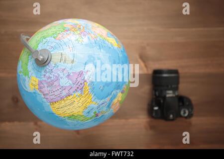 Elche, Espagne. 31 mars 2016 : Globe et une caméra sur fond de bois Banque D'Images