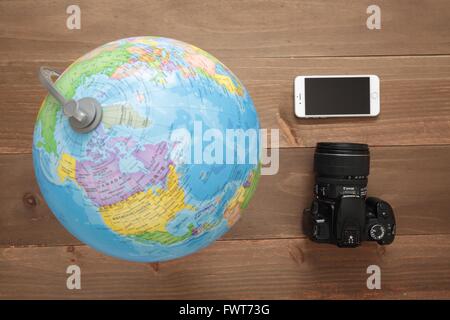 Elche, Espagne. 31 mars 2016 : Globe, appareil photo et mobiles sur fond de bois Banque D'Images