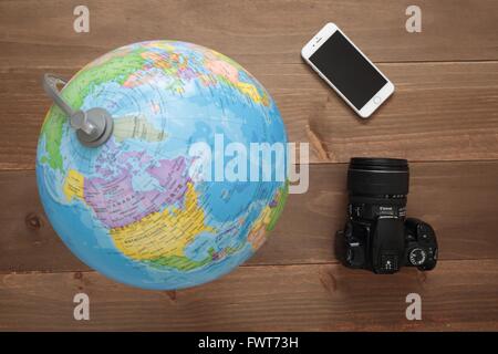 Elche, Espagne. 31 mars 2016 : Globe, appareil photo et mobiles sur fond de bois Banque D'Images