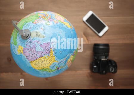 Elche, Espagne. 31 mars 2016 : Globe, appareil photo et mobiles sur fond de bois Banque D'Images