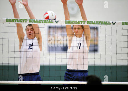 Deux joueurs se tapir en prévision d'un bloc, mais possible, un kill shot se précipita passé la paire dans un match de volley-ball de l'école secondaire. USA. Banque D'Images