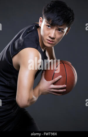 Jeune homme jouant au basket-ball Banque D'Images