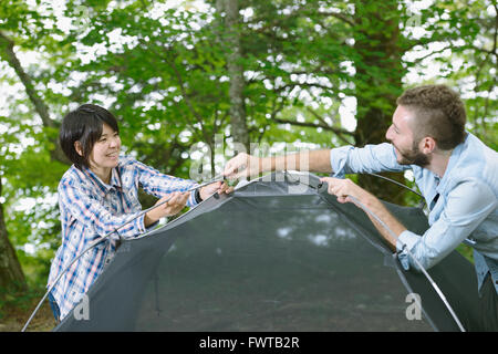 Les amis de mettre en place une tente sur un terrain de camping Banque D'Images