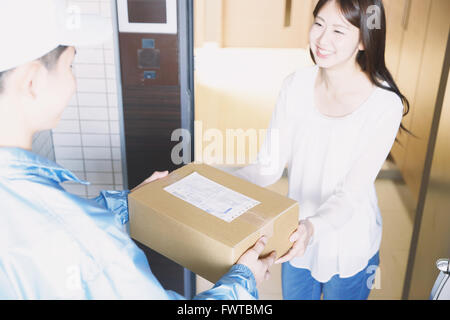 Jeune japonaise se package delivery man Banque D'Images