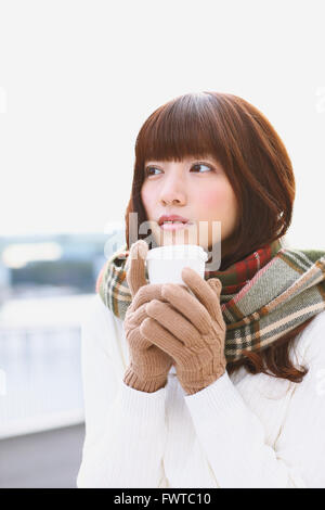 Jolie femme japonaise avec du café sur une journée d'hiver Banque D'Images