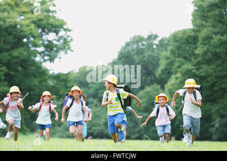 Les enfants japonais s'exécutant dans un parc de la ville Banque D'Images