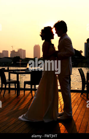 Silhouette de mariée et le Marié baiser sur la mariage romantique le long de la rivière Chaophraya , Bangkok Thaïlande Banque D'Images