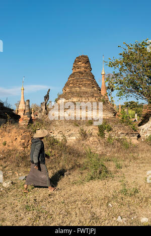 Homme marche par effritement temple (stupa) dans Sankar près du lac Inle, en Birmanie (Myanmar) Banque D'Images