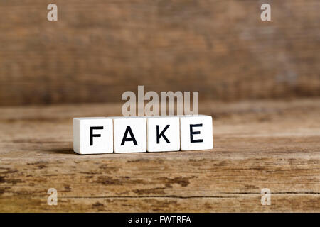 Le mot fake written en cubes sur fond de bois Banque D'Images
