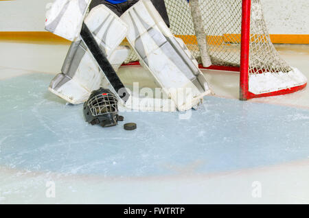 Un gardien de but de hockey prépare lui-même dans le pli et le bénéfice net avant le jeu en Rink Banque D'Images