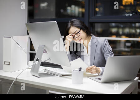 Businesswoman working in office tardif Banque D'Images