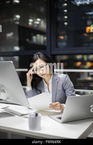 Businesswoman working in office tardif Banque D'Images