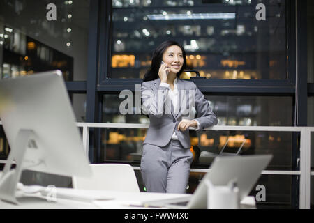 Businesswoman talking on the phone in office Banque D'Images