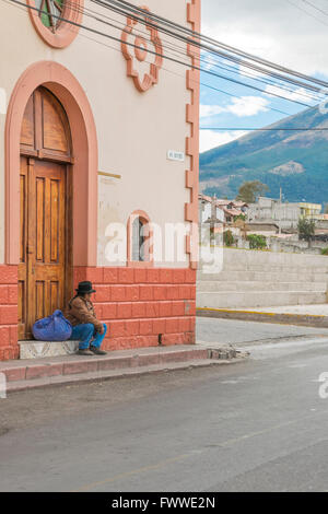 OTAVALO, EQUATEUR, octobre - 2015 - Les homme assis sur trocal de la sierra street sur la route vers le lac San Pablo dans t Banque D'Images