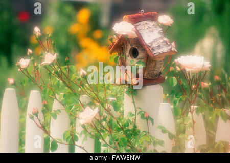 Maison d'oiseau sur un Fencepost entouré de Roses, Cape Cod, Massachusetts, États-Unis Banque D'Images