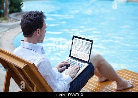 Bourse en ligne, homme d'affaires travaillant avec les données financières en ligne sur ordinateur portable proche piscine Banque D'Images