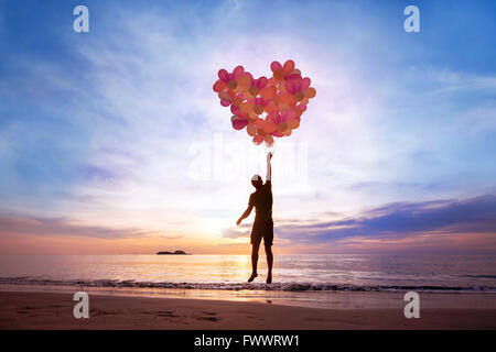 Concept L'amour, l'homme avec l'aide de ballons coeur battant, tomber en amour Banque D'Images