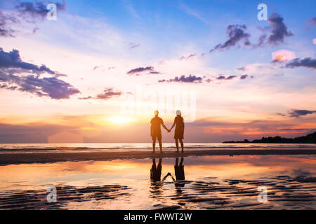 Couple romantique sur la plage au coucher du soleil, les silhouettes de l'homme et de la femme ensemble Banque D'Images