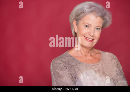 Seior Happy woman in front of white background Banque D'Images