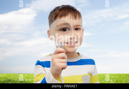 Happy little boy looking through magnifying glass Banque D'Images