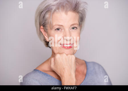 Portrait of a young woman in front of fond gris Banque D'Images