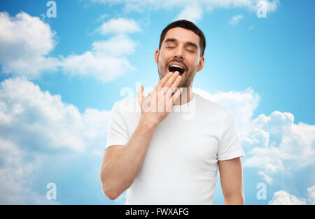 Le bâillement l'homme sur fond de ciel bleu Banque D'Images