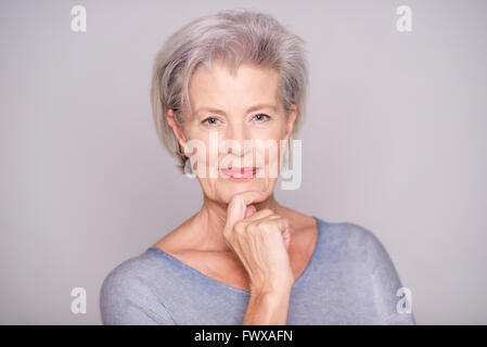 Portrait of a young woman in front of fond gris Banque D'Images