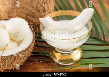 Verre à liqueur de noix de coco servi avec des noix de coco fraîche Banque D'Images