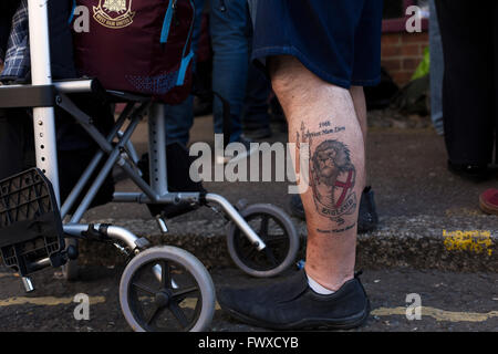 Un homme avec un tatouage sur la jambe de l'Angleterre, que l'on voit près du Boleyn Ground avant de West Ham United Crystal Palace a accueilli dans un match de la Barclays Premier League. Le Boleyn Ground à Upton Park a été le terrain d'accueil du club de 1904 jusqu'à la fin de la saison 2015-2016 quand ils se sont déplacés dans le Stade Olympique, construit pour les Jeux de Londres en 2012, à proximité de Stratford. Le match s'est terminé dans un 2-2 draw, surveillée par une foule presque à capacité de 34 857. Banque D'Images