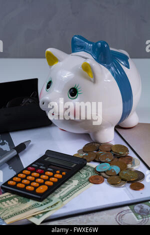 Tirelire et les accessoires, lunettes, calculatrice sur fond blanc Banque D'Images