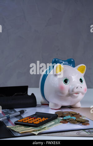 Tirelire et les accessoires, lunettes, calculatrice sur fond blanc Banque D'Images