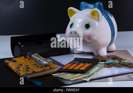 Tirelire et les accessoires, lunettes, calculatrice sur fond blanc Banque D'Images