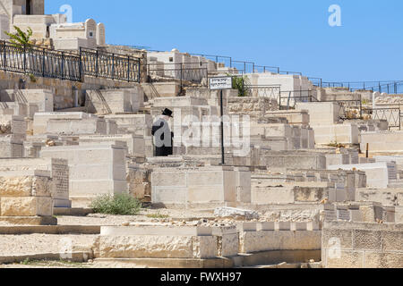 Juif religieux prie à l'ancien cimetière juif sur le Mont des Oliviers à Jérusalem, Israël. Banque D'Images