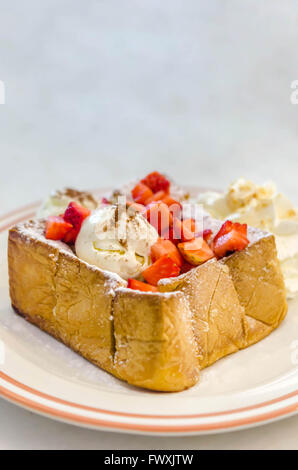 Toast au miel fraises avec de la crème glacée et la crème fouettée Banque D'Images