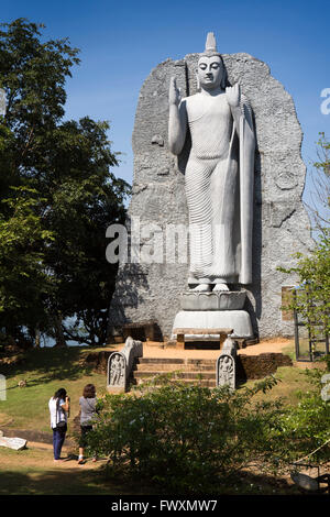 Minneriya, Sri Lanka, visiteurs à grand Bouddha debout à côté du Lac-de-Minneriya Banque D'Images