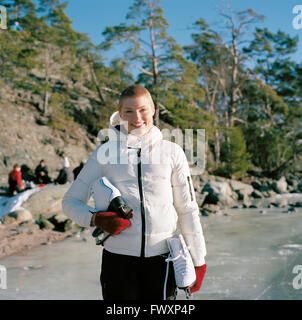 La Suède, l'Uppland, Varmdo, Bjorno, Portrait of mid adult woman holding patins à glace