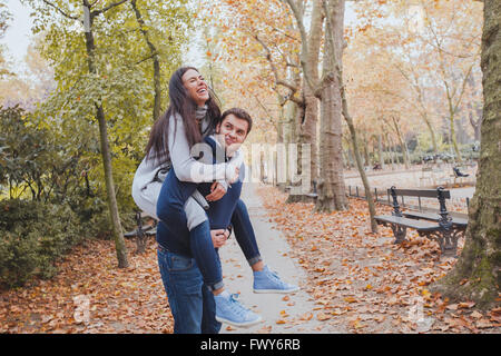 Happy young couple having fun in autumn park, caucasian family, homme et femme, piggyback Banque D'Images