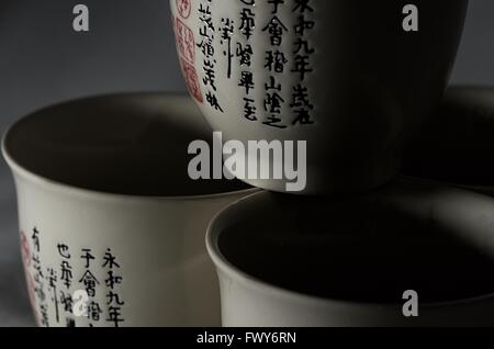 Trois tasses avec symboles chenese, fond noir Banque D'Images