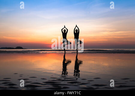 Yoga sur la plage, groupe de personnes qui pratiquent un mode de vie sain Banque D'Images