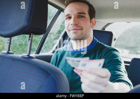 Heureux passager en taxi paiement en argent Banque D'Images