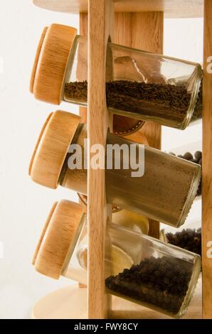Support en bois avec des épices dans des bocaux isolé sur fond blanc. Banque D'Images