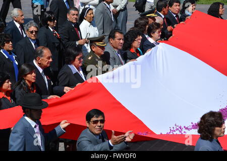 Politiciens et dignitaires portent le drapeau péruvien et parade autour de la Plaza de Armas pour Dia del Folclor à Cusco au Pérou. Banque D'Images