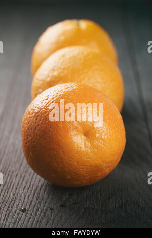 Trois oranges frais mûrs sur table en bois de chêne Banque D'Images