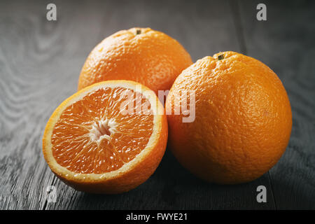 Trois oranges frais mûrs sur table en bois de chêne Banque D'Images