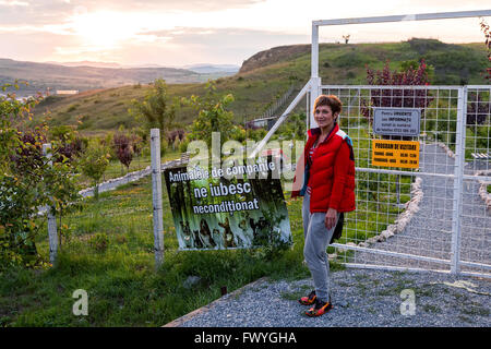 Hunedoara, Roumanie - 21 juin 2014 : Blonde femme heureuse, l'administrateur du cimetière pour animaux, devant le cimetière Animal Banque D'Images